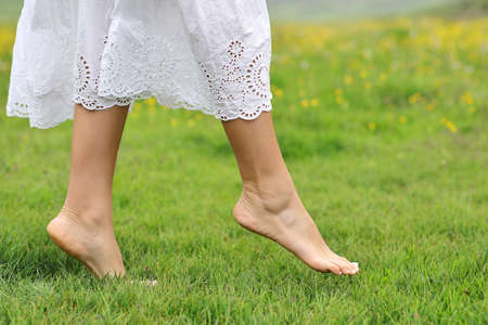 Close up side view portrait of a woman bare feet walking on the grass in the mountain