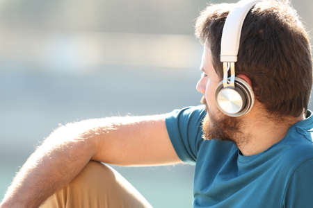Rwelaxed man listening to music with headphones contemplating views in natureの写真素材