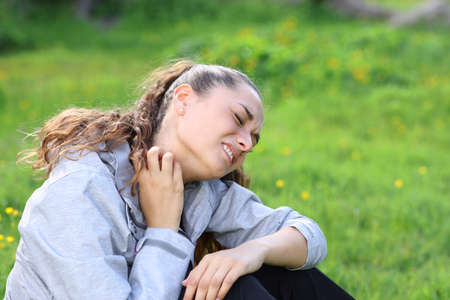 Hiker scratching itchy neck complaining after insect bite in the mountain