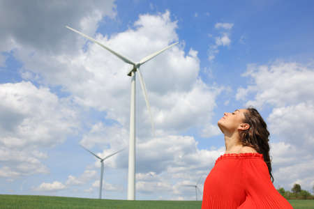 Profile of a woman in red breathing fresh air in a wind farm