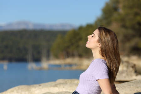 Profile of a relaxed happy teenager breathing fresh air in a lochの写真素材