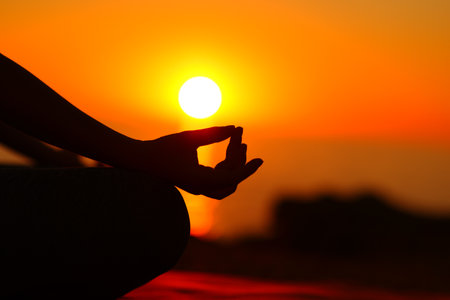 Close up portrait of a yogi hand silhouette at sunset doing yogaの写真素材