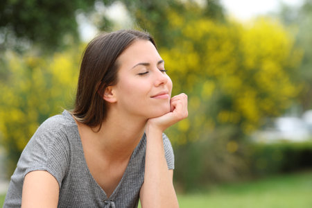 Satisfied teen relaxing sitting in a parkの写真素材