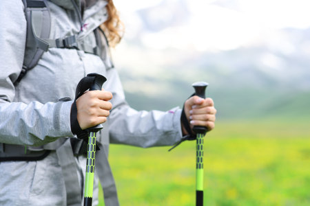 Close up of a hiker hands using poles in the mountainの写真素材