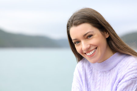 Happy beautiful teenager looking at camera in a lakeの写真素材