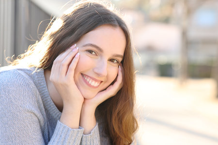 Beautiful woman looking at camera smiling sitting in the streetの写真素材