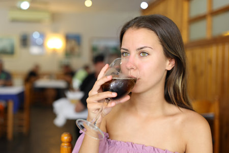 Woman drinking soda alone in a restaurantの写真素材