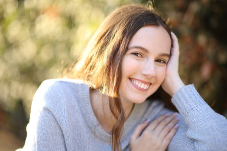 Portrait of a happy woman looking at camera sitting in a parkの写真素材