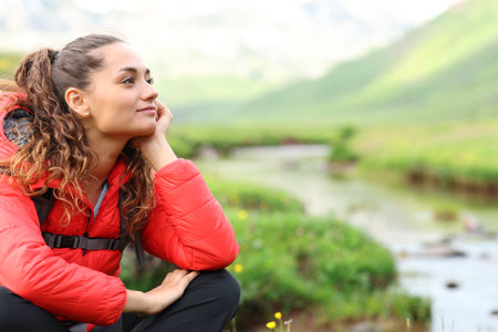 Relaxed hiker in red resting contemplating views in natureの写真素材
