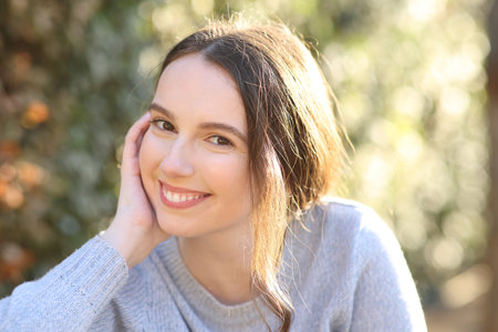 Portrait of a beautiful woman posing sitting in a parkの写真素材
