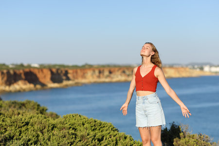Teen breathing fresh air on the coast on a sunny dayの写真素材