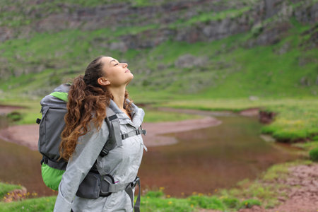 Profile of a hiker breathing fresh air in a riversideの写真素材
