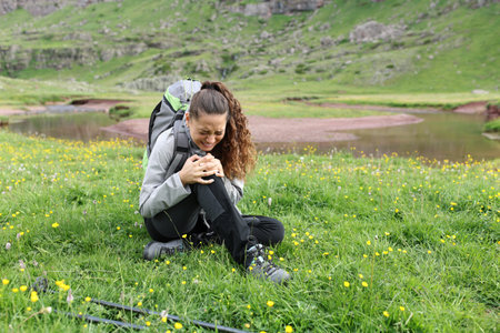 Hiker complaining suffering knee ache after accident in the mountainの写真素材