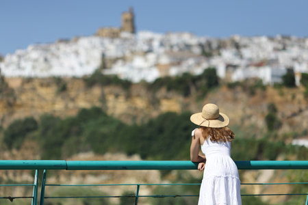 Back view portrait of a tourist contemplating Spanish town viewsの写真素材