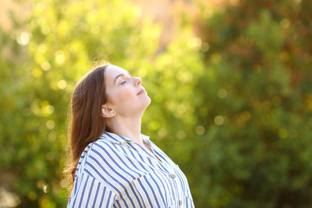 Profile of a woman breathing in a park fresh airの写真素材