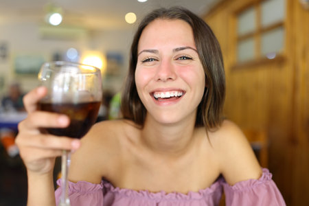 Front view of a happy teen laughing holding soda cup in a restaurantの写真素材