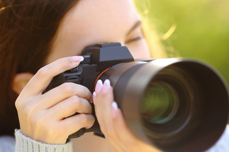 Close up portrait of a photographer taking picture with mirrorless camera on green