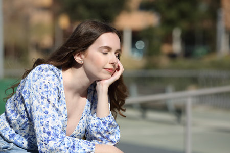 Relaxed woman resting seated in a park on a sunny dayの写真素材