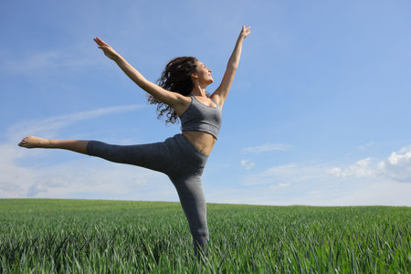 Happy woman danding in a green fieldの写真素材