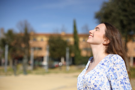Profile of a happy woman breathing fresh air in a residential area parkの写真素材