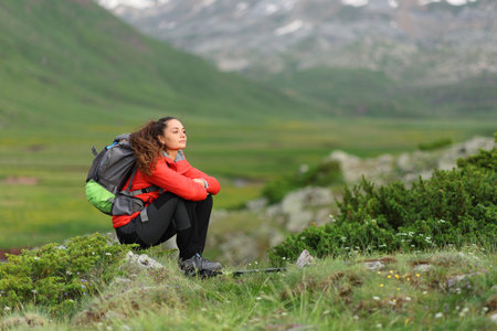 Hiker sitting in a beautiful valley looking awayの写真素材