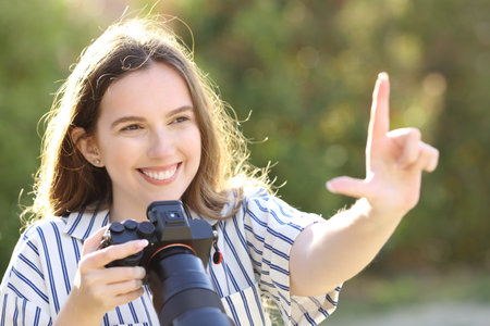 Happy photographer calculating frame with her hand holding mirrorless cameraの写真素材