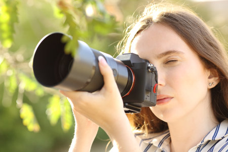 Photographer taking photos with a mirrorless camera in a parkの写真素材