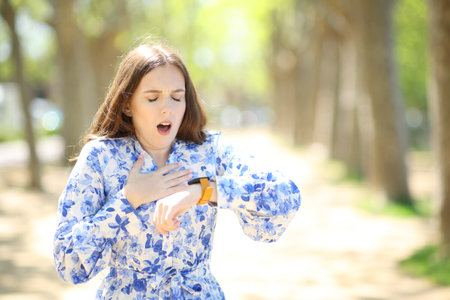 Asthmatic woman controlling pulsations on smartwatch choking in a parkの写真素材