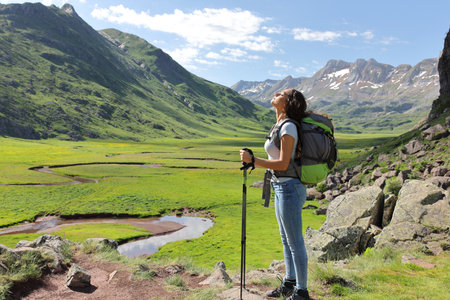 Side view full body portrait of a relaxed hiker breathing fresh air in a mountain valleyの写真素材