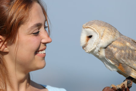 Happy woman and owl looking at each otherの写真素材