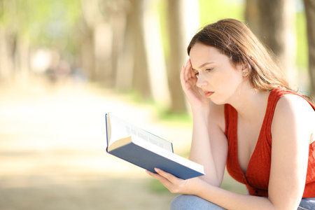 Profile of a worried book reader in a parkの写真素材