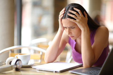 Worried student trying to memorize a lesson from notebook in a bar terraceの写真素材