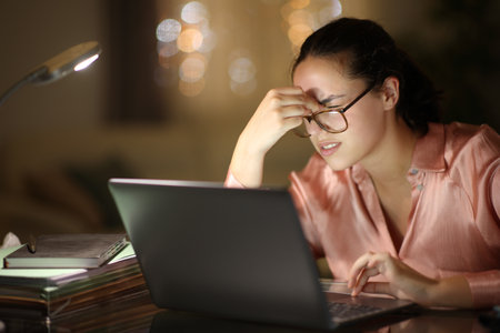 Entrepreneur wearing eyeglasses working suffering eyestrain in the night at homeの写真素材