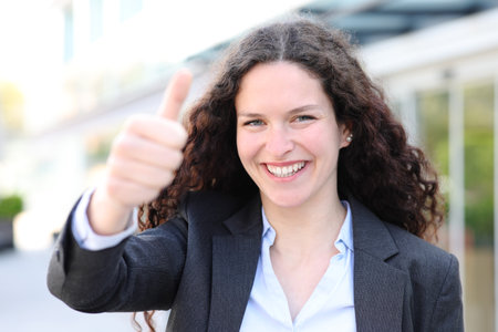 Happy executive showing thumb up in the streetの写真素材
