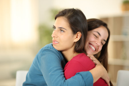 Happy woman hugging a false friend in the living room at homeの写真素材