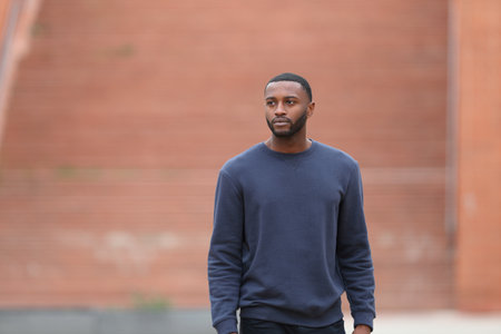 Front view portrait of a black man walking in a parkの写真素材