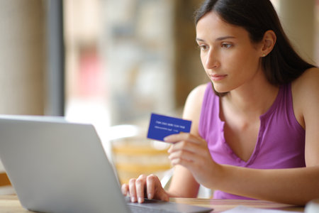 Serious woman buying online in a coffee shop terrace outdoorの写真素材