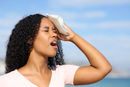 Overwhelmed black woman drying sweat a hot day on the beachの写真素材