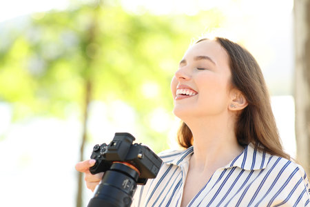 Happy photographer breathing fresh air standing in the mountainの写真素材