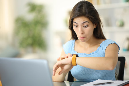 Perplexed student checking smartwatch content at homeの写真素材