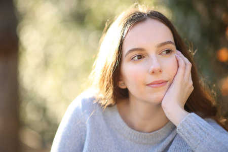 Pensive woman looking away in a gardenの写真素材