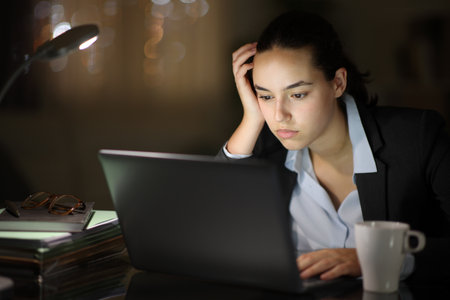 Serious executive working online with a laptop in the nightの写真素材