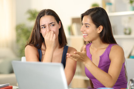 Woman with bad breath talking to a disgusted friend at homeの写真素材