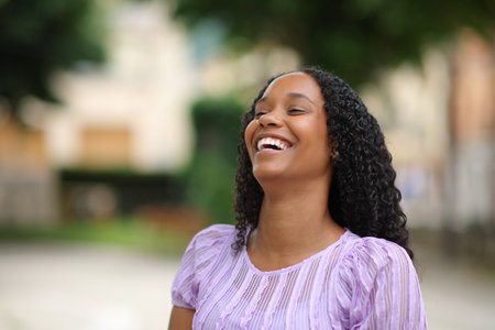 Happy black woman laughing loud alone in the streetの写真素材