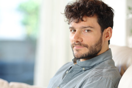 Portrait of a serious confident man looking at camera at homeの写真素材