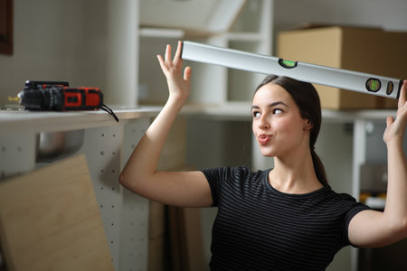 Woman playing with a level meter in a house under renovation