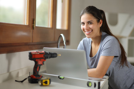 Happy homeowner renovating house using laptop looks at youの写真素材