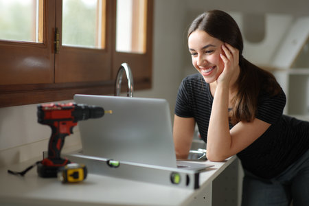 Happy woman planning house renovation online with a laptopの写真素材