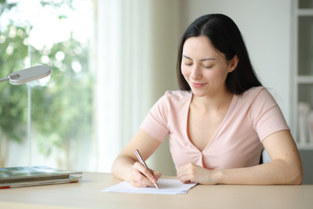 Asian woman filling form or signing contract in a desk at homeの写真素材