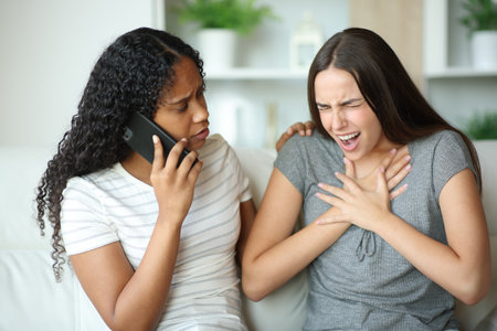Woman choking and partner calling doctor with phone at homeの写真素材